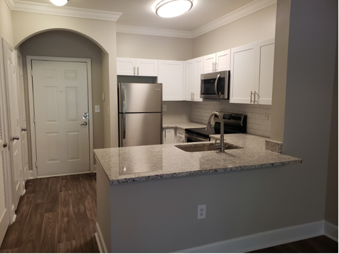 a kitchen with a granite counter top and a stainless steel refrigerator
